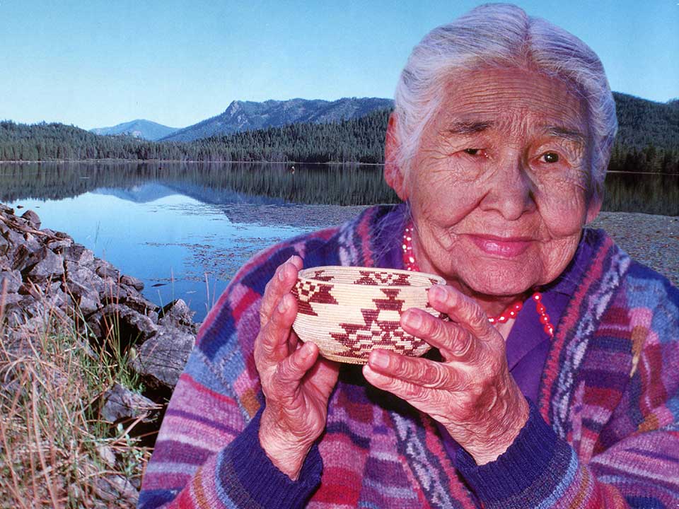 Elder Greenville woman holding a traditional-style bowl and standing in front of a lake